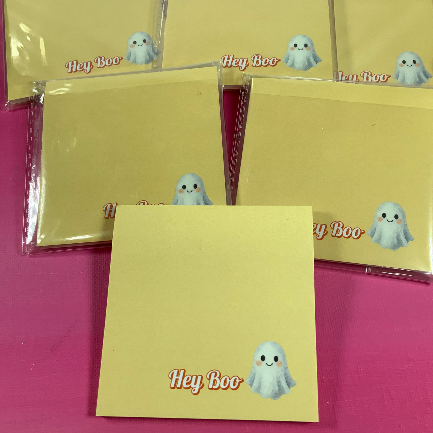 Yellow notepads with 'Hey Boo' design on a pink background