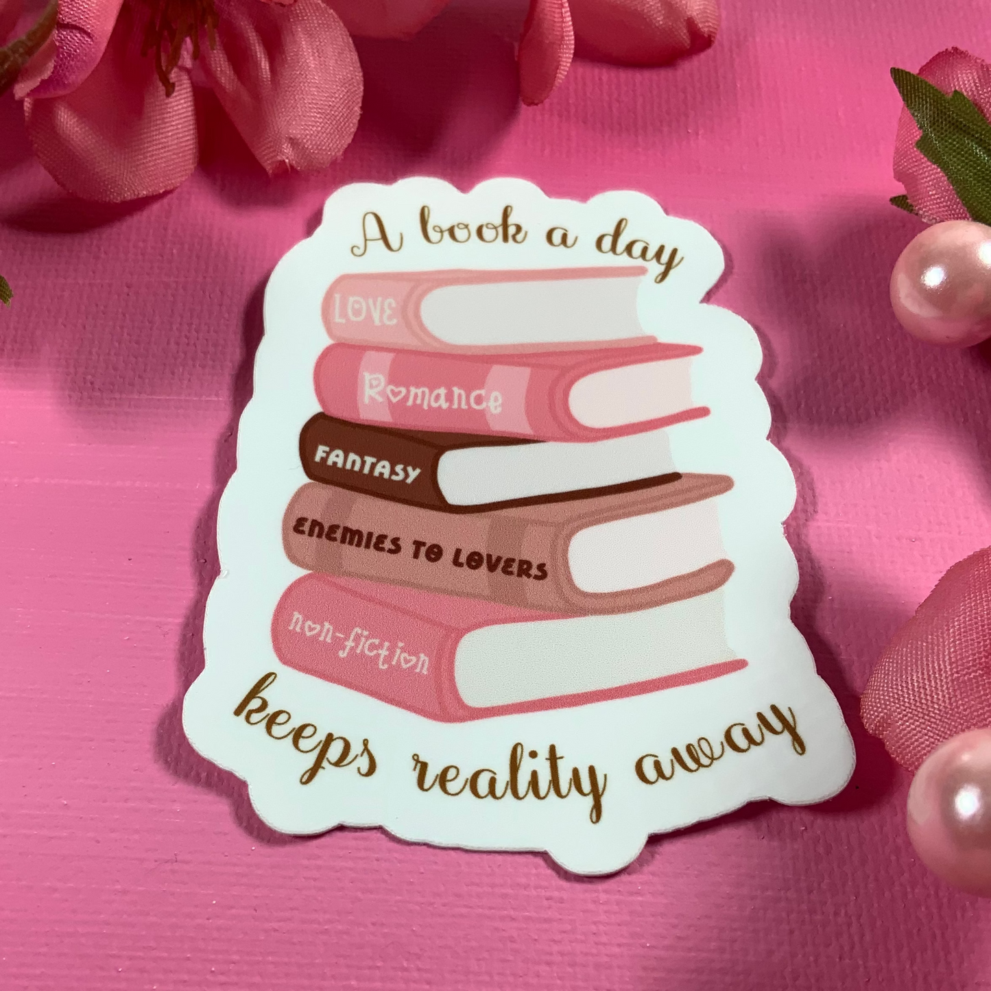 Book-themed decorative sticker on a pink background with floral elements