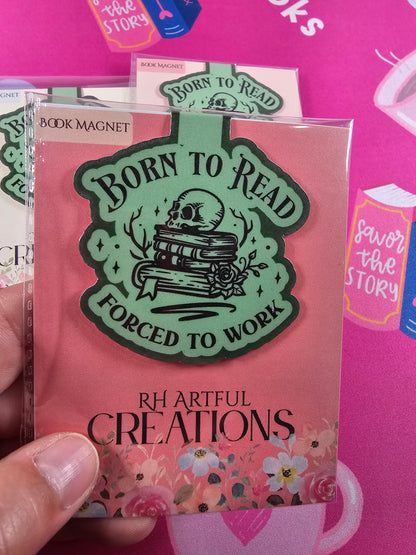 Pink book with green 'Born to Read' design held against a pink background