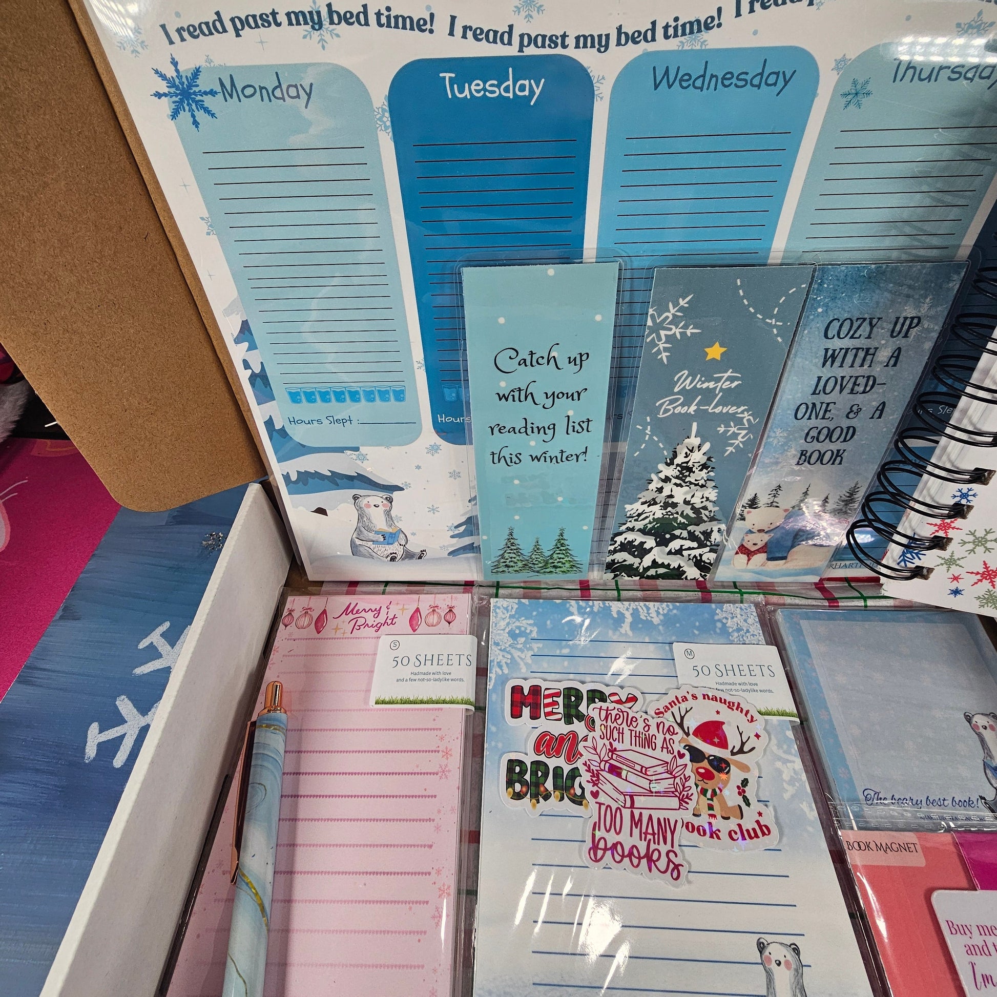 Open planner with various pages and a pink cover