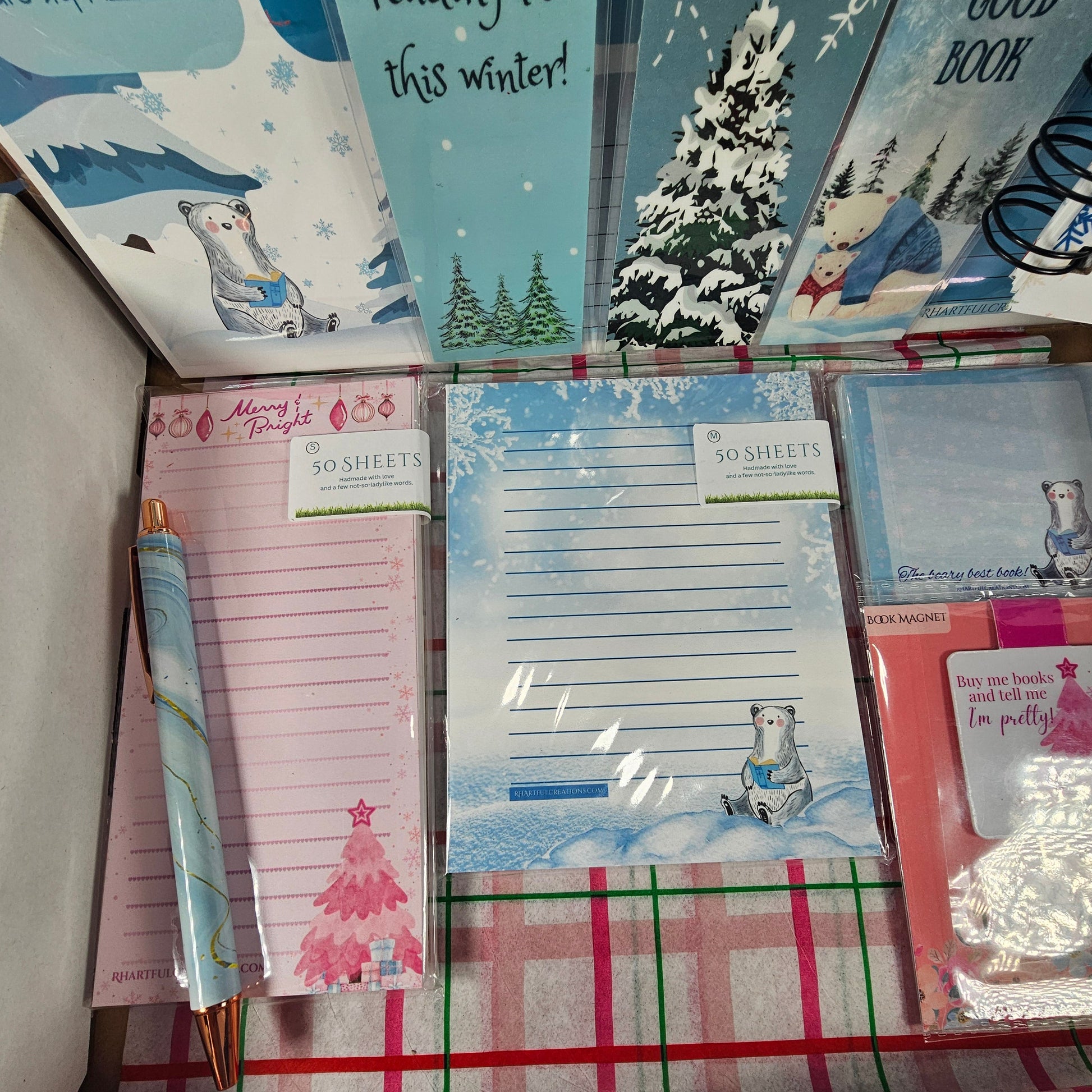 Collection of stationery items including notebooks and lists on a checkered fabric background