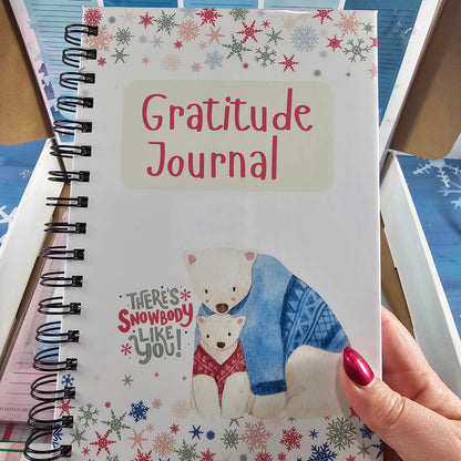 Gratitude journal with winter-themed cover held by a hand