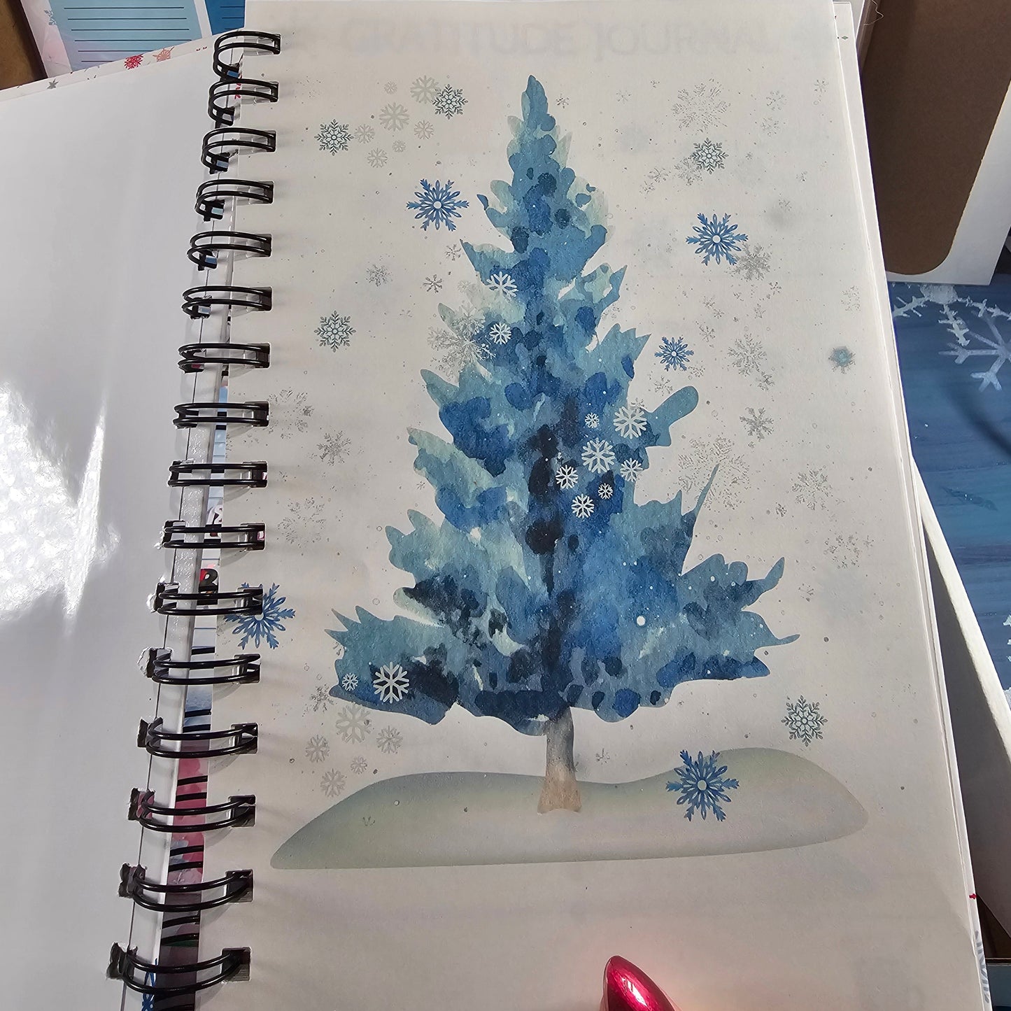 Notebook with blue floral design and snowflakes on a white background