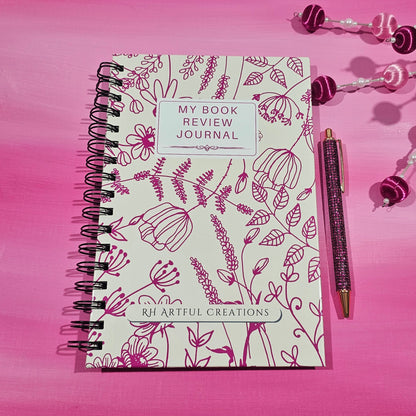 Valentine-themed spiral book review journal with magenta floral cover by RH Artful Creations on a pink background.