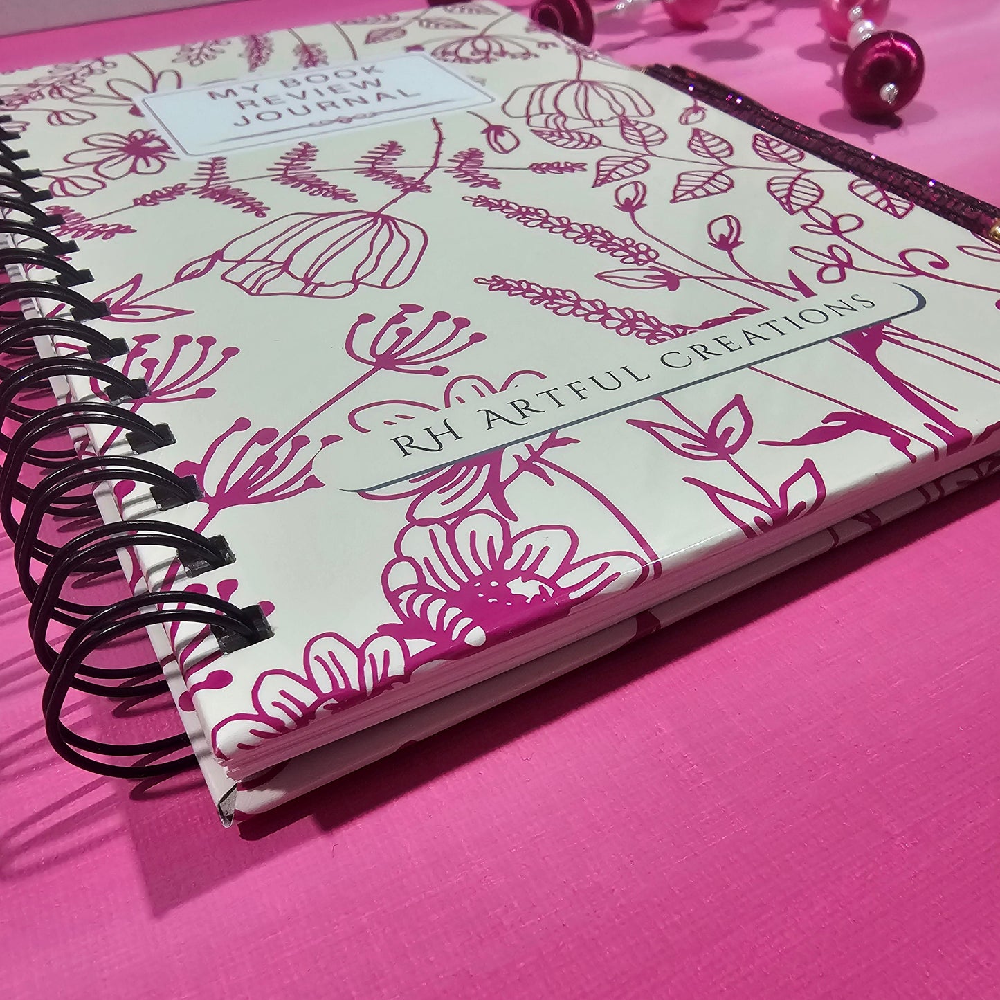 Notebook with floral design on a pink background