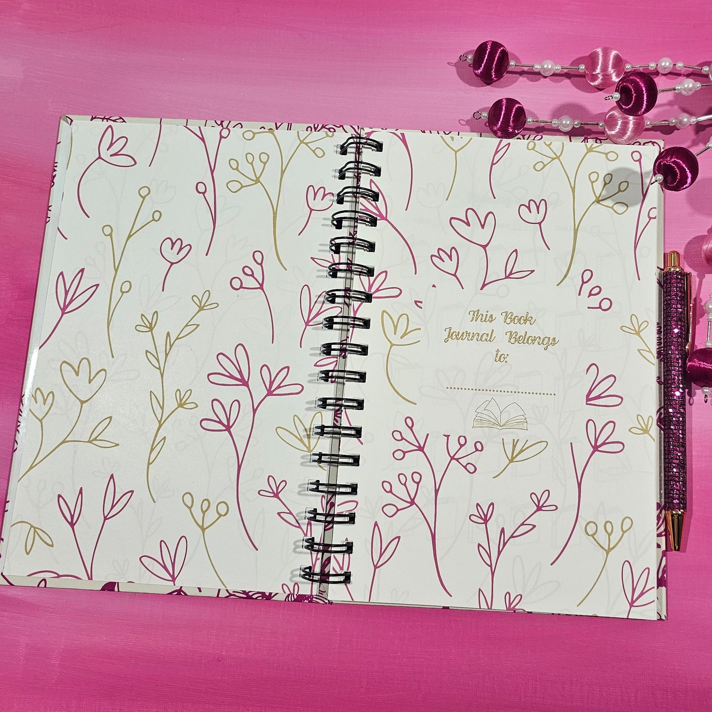 Notebook with floral design on a pink background