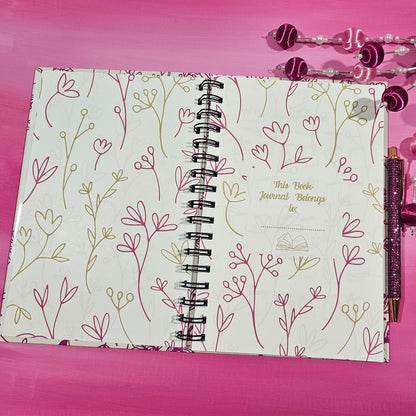 Notebook with floral design on a pink background
