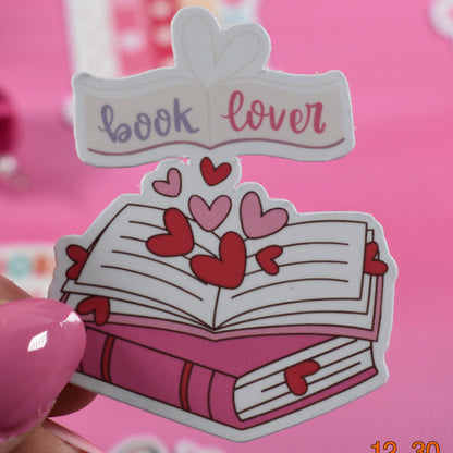 Sticker with 'book lover' text and hearts on a pink background