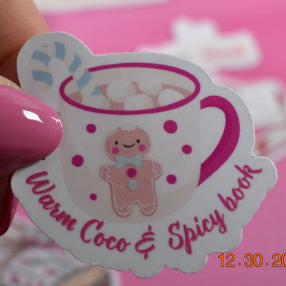 Hand holding a sticker with a cartoon bear and text against a pink background