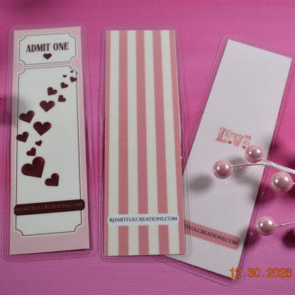 Three decorative bookmarks with heart designs on a pink background