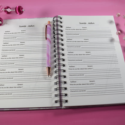 Open notebook with a pen on a pink background