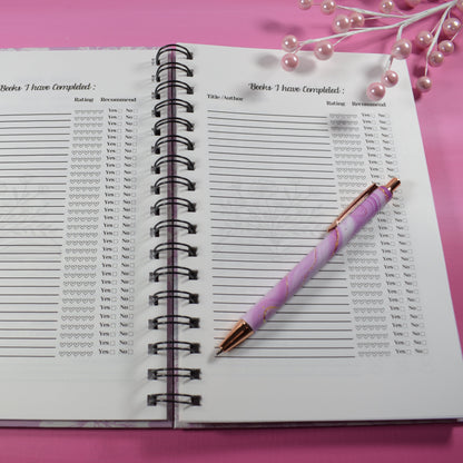 Notebook with a pen on a pink surface
