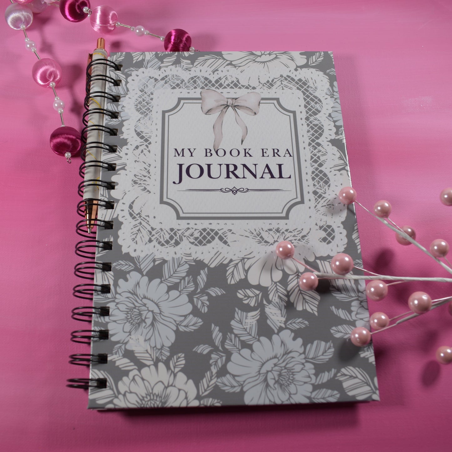 Journal with floral design and 'My Book Era Journal' text on a pink background