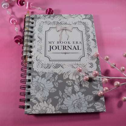 Journal with floral design and 'My Book Era Journal' text on a pink background