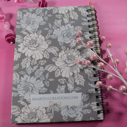 Floral notebook on a pink background with decorative elements