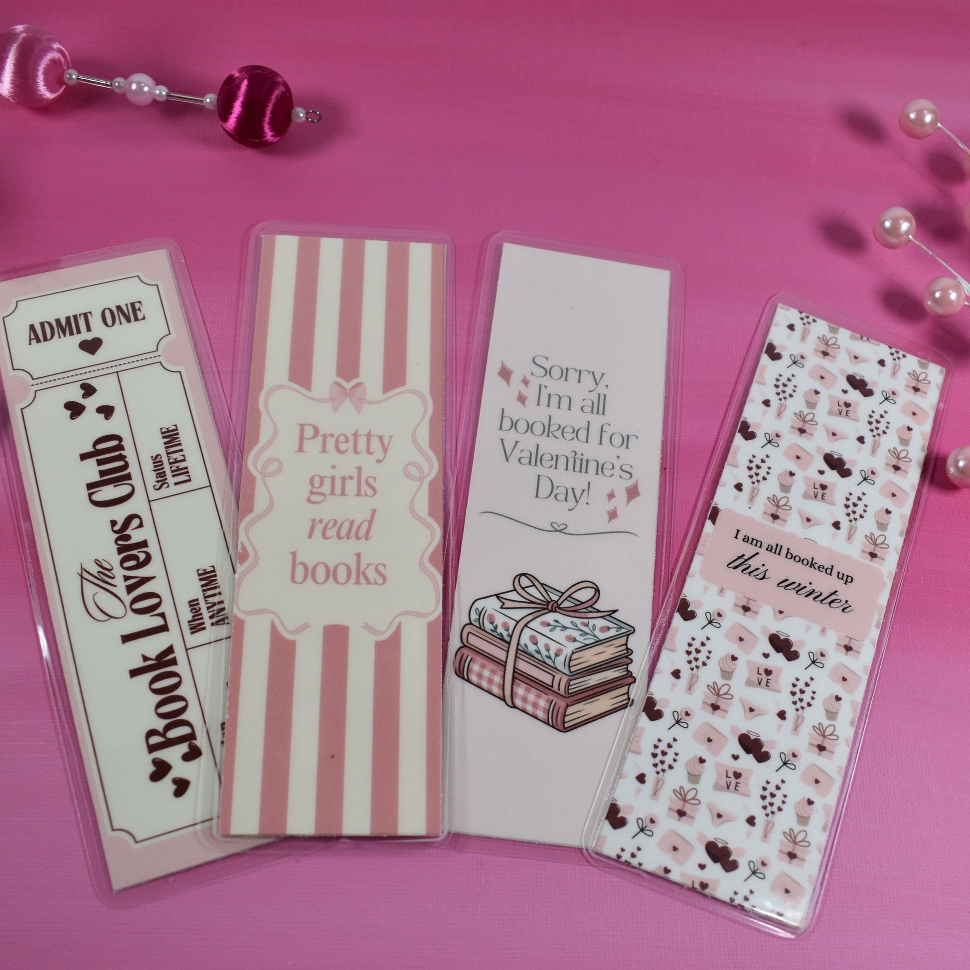 Four pink bookmarks with different designs on a pink background