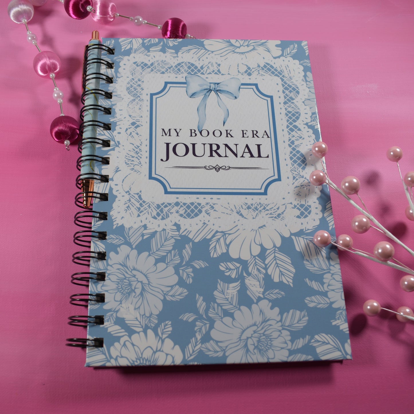 Journal with floral design and 'My Book Era Journal' text on a pink background