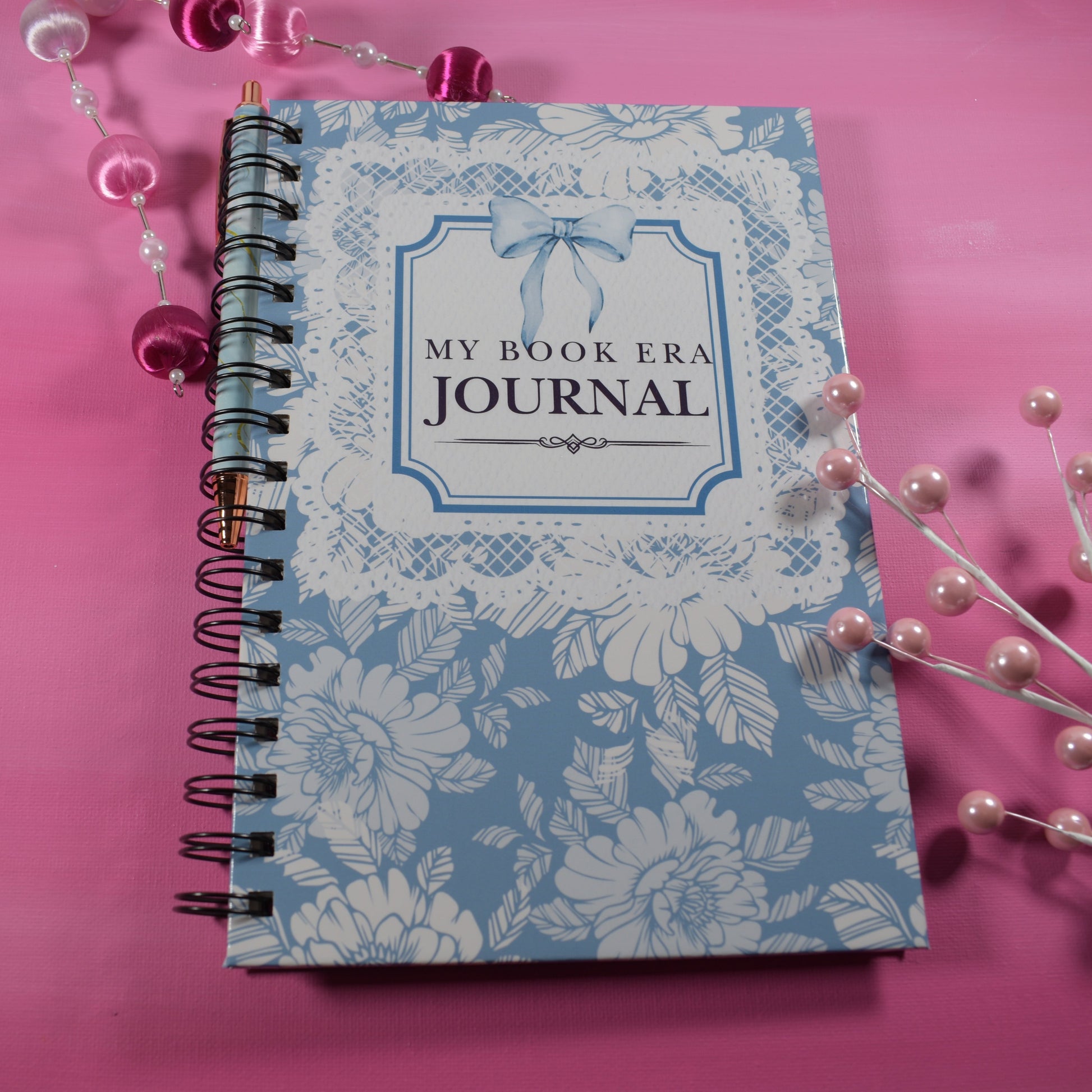 Journal with floral design and 'My Book Era Journal' text on a pink background