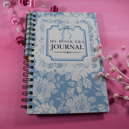 Journal with floral design and 'My Book Era Journal' text on a pink background