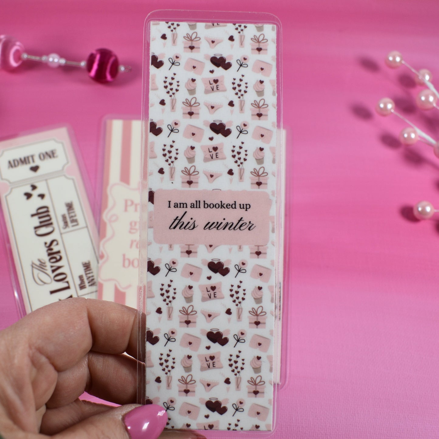 Hand holding a sheet of decorative stickers with a pink background