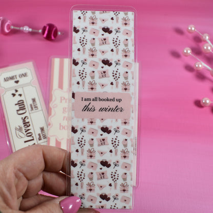 Hand holding a sheet of decorative stickers with a pink background