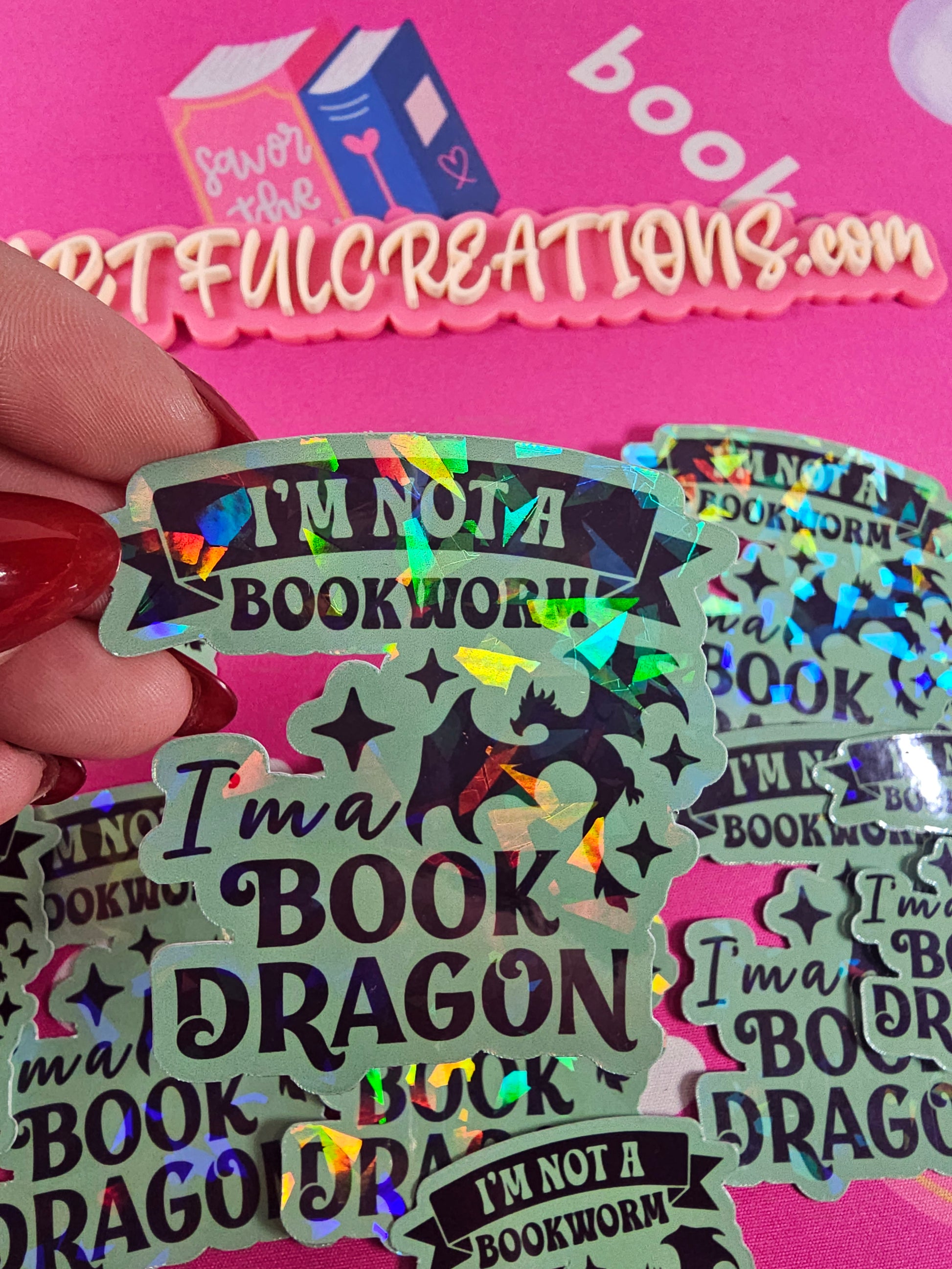 “I’m Not a Bookworm, I’m a Book Dragon” holographic vinyl sticker with rainbow sparkle finish, handmade by RH Artful Creations.