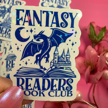 Sticker with 'Fantasy Readers Book Club' design held by a hand against a pink background with flowers.