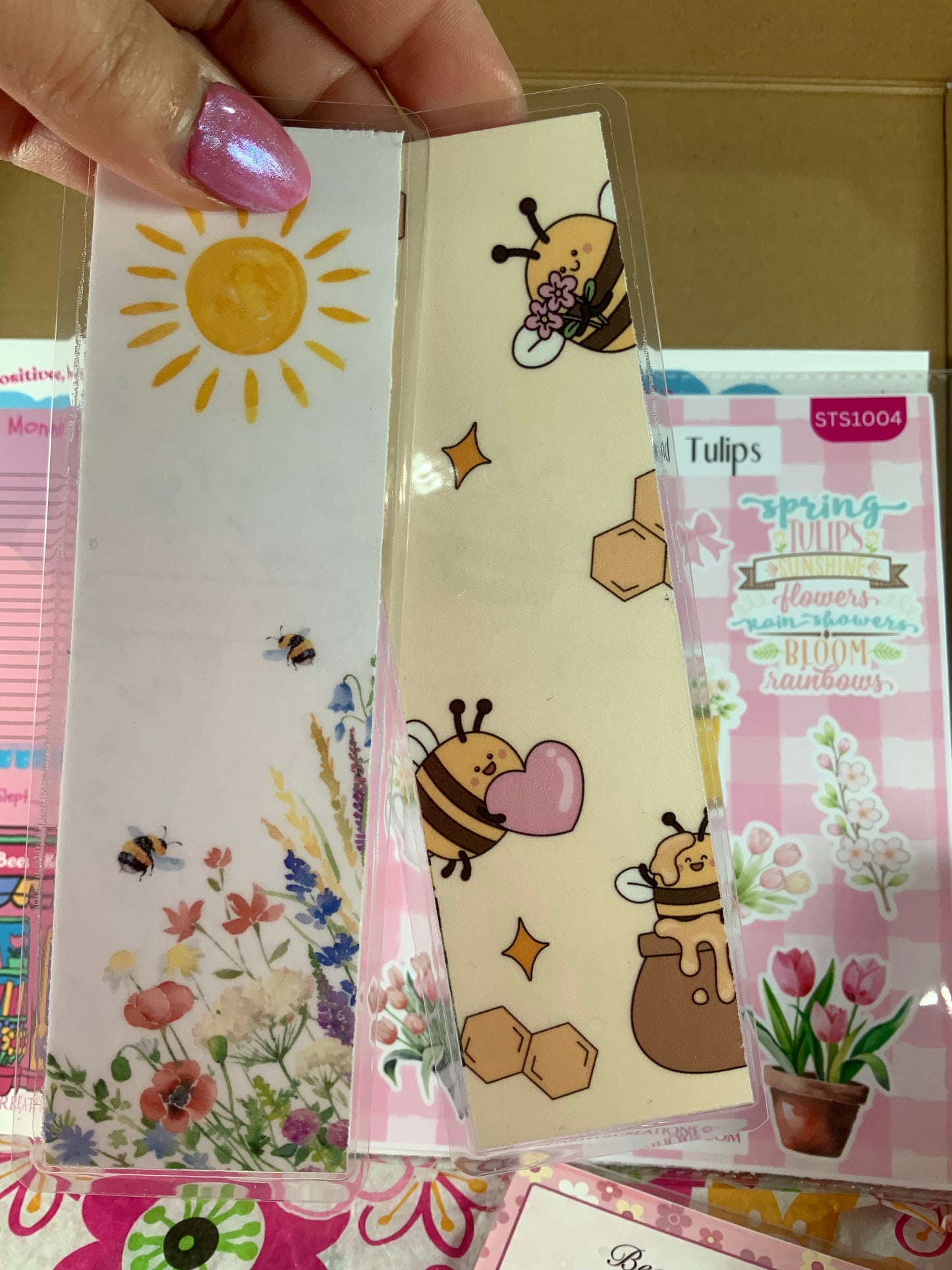 Set of decorative stationery items with sun, bee, and flower designs on a colorful background.