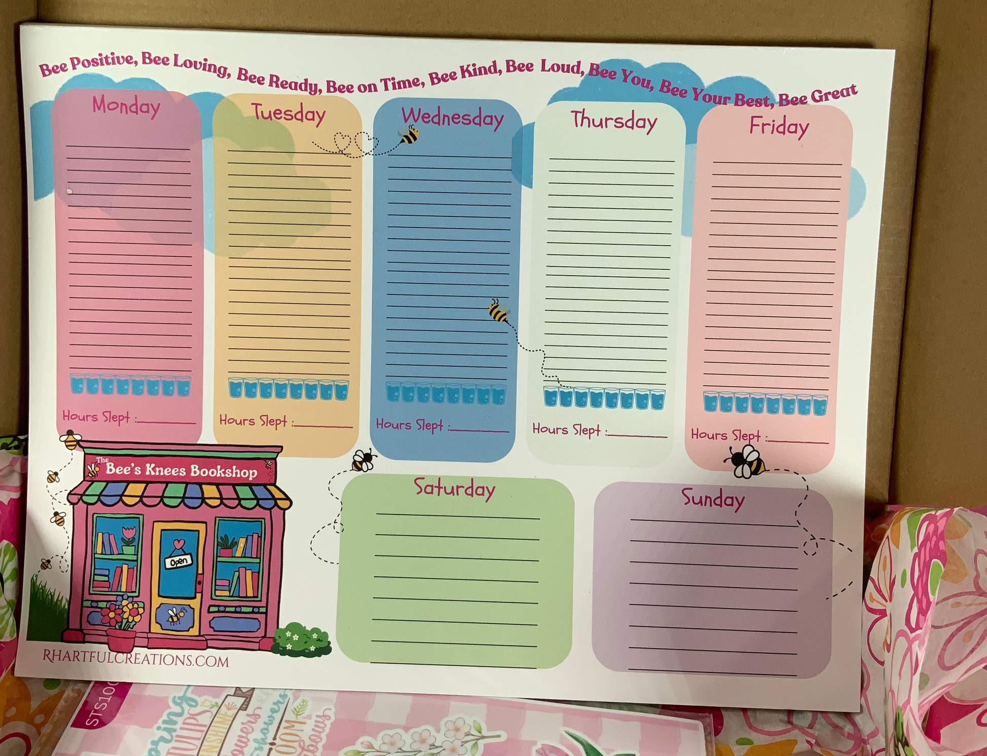 Set of colorful weekly planner stickers with a house illustration on a cardboard background.