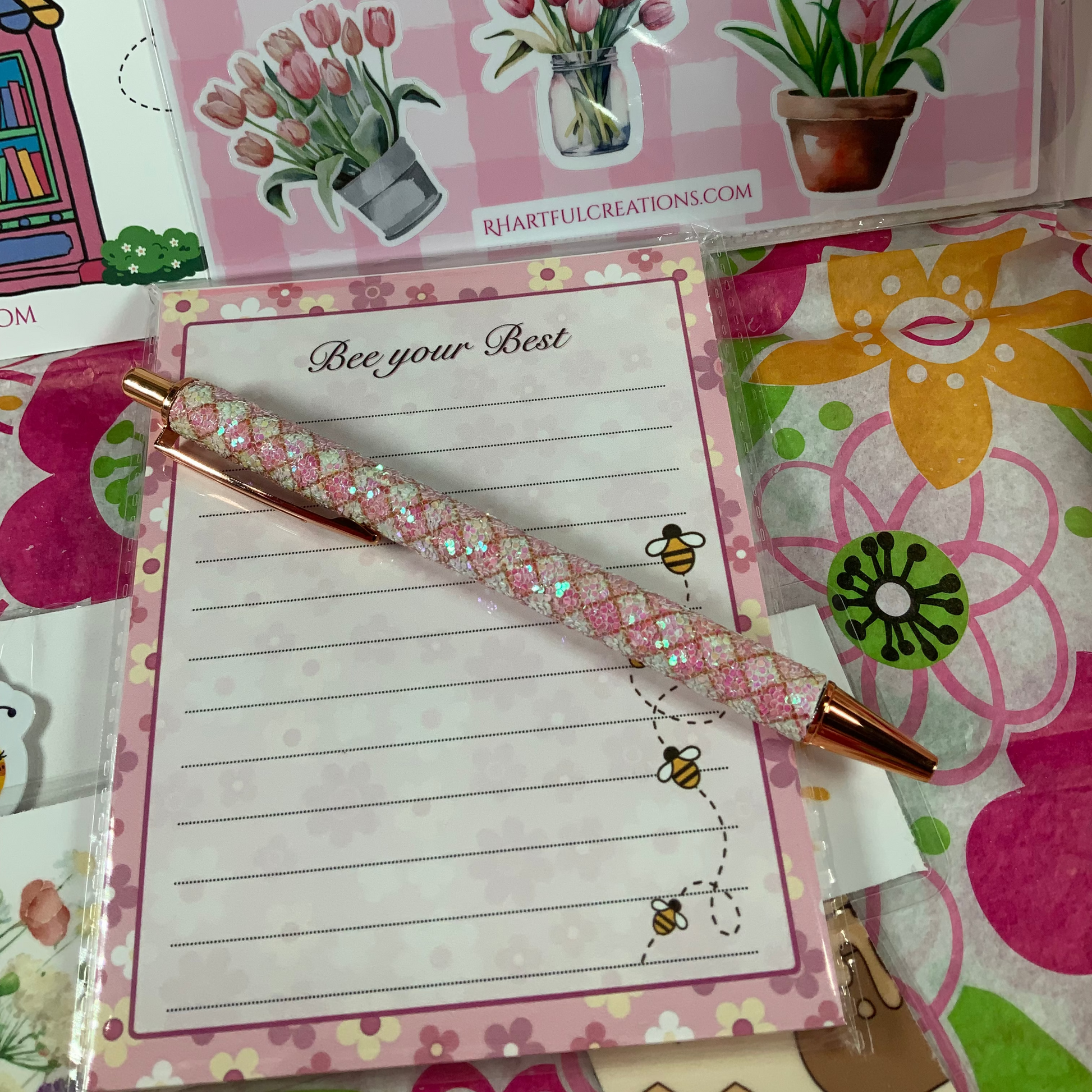 Notebook with decorative pen and floral-themed stickers on a colorful background
