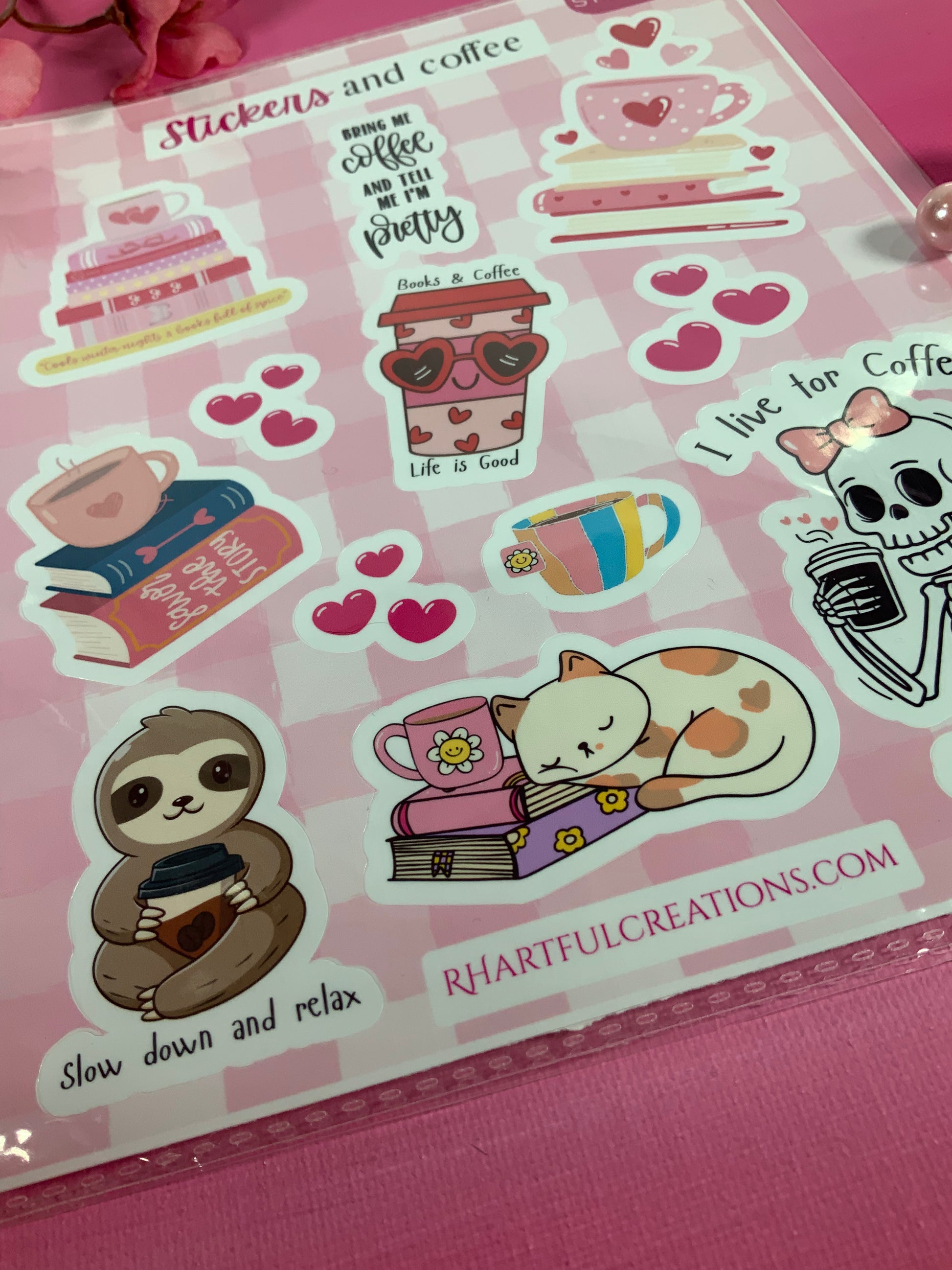 Sheet of stickers with various designs including a sloth, cat, and coffee-themed items on a pink background.