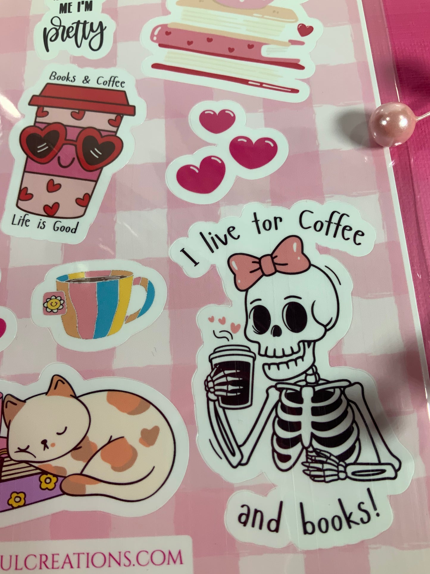 Sticker sheet with a skeleton holding a coffee cup and text 'I live for coffee and books!' on a pink background.