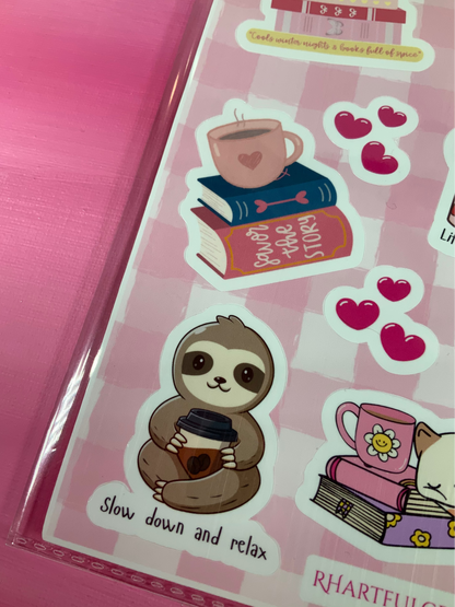Sheet of stickers with a sloth holding a coffee cup and other decorative elements on a pink background.