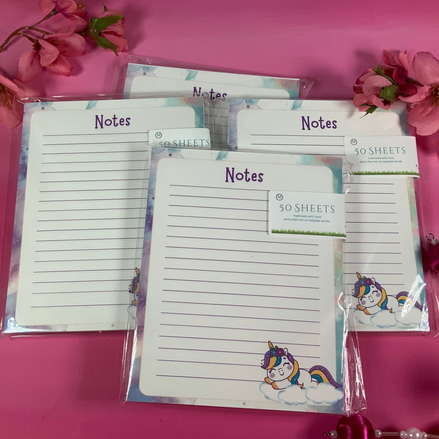 Note pads with unicorn design on a pink background with flowers