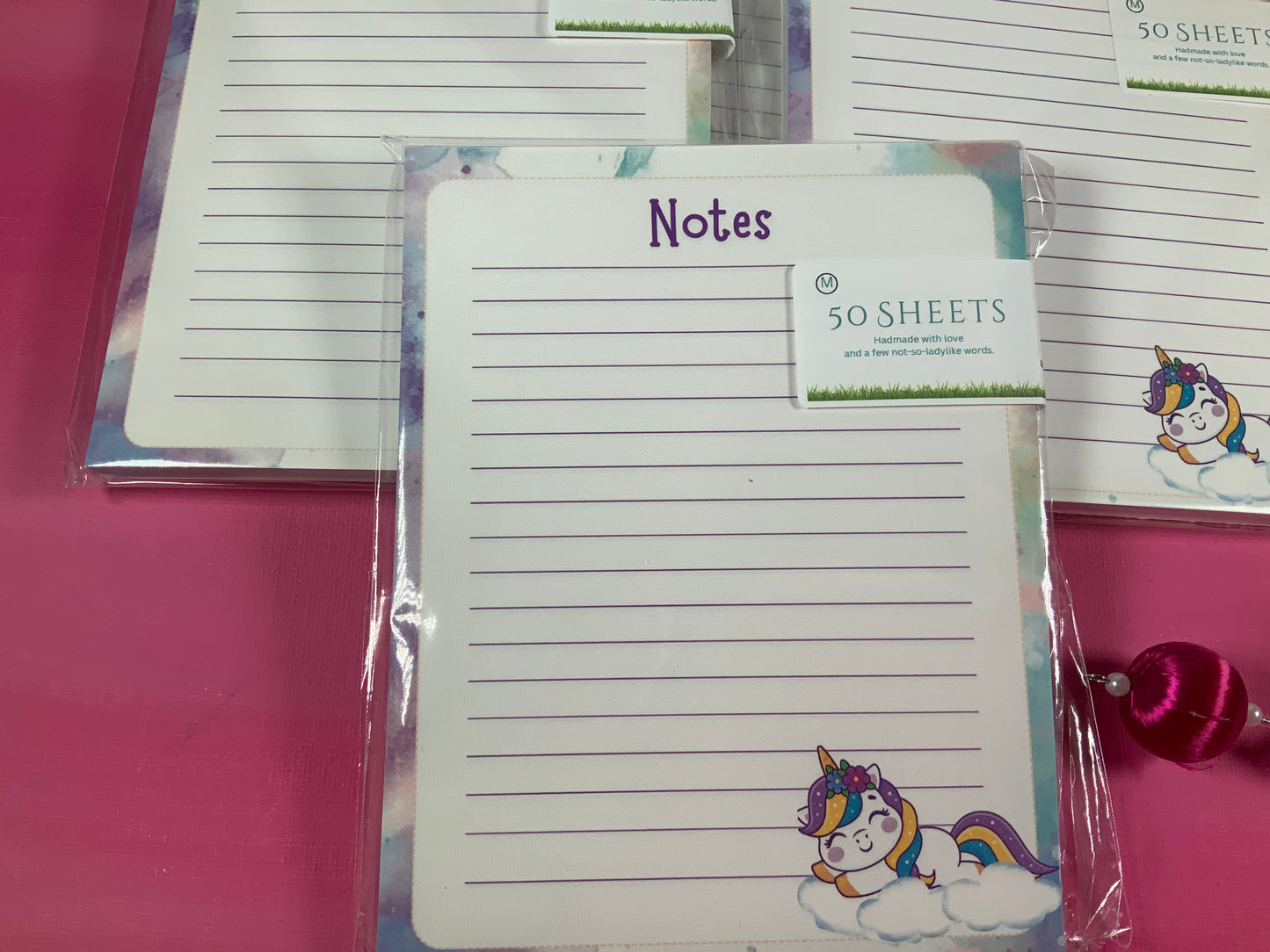 Notepad with unicorn design and 'Notes' text on a pink surface