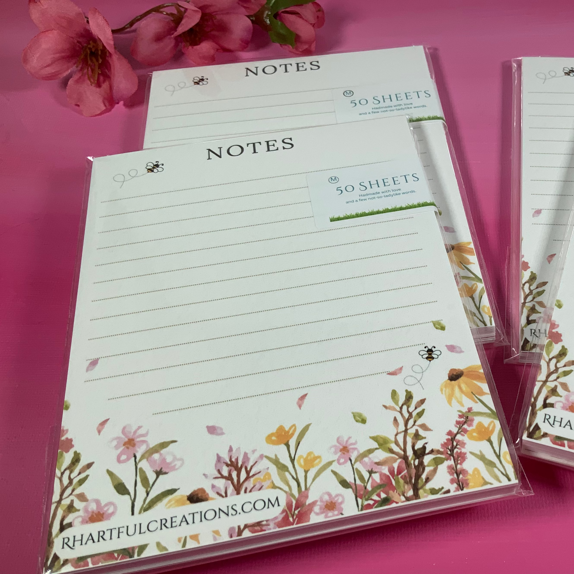 Notebooks with floral designs on a pink background