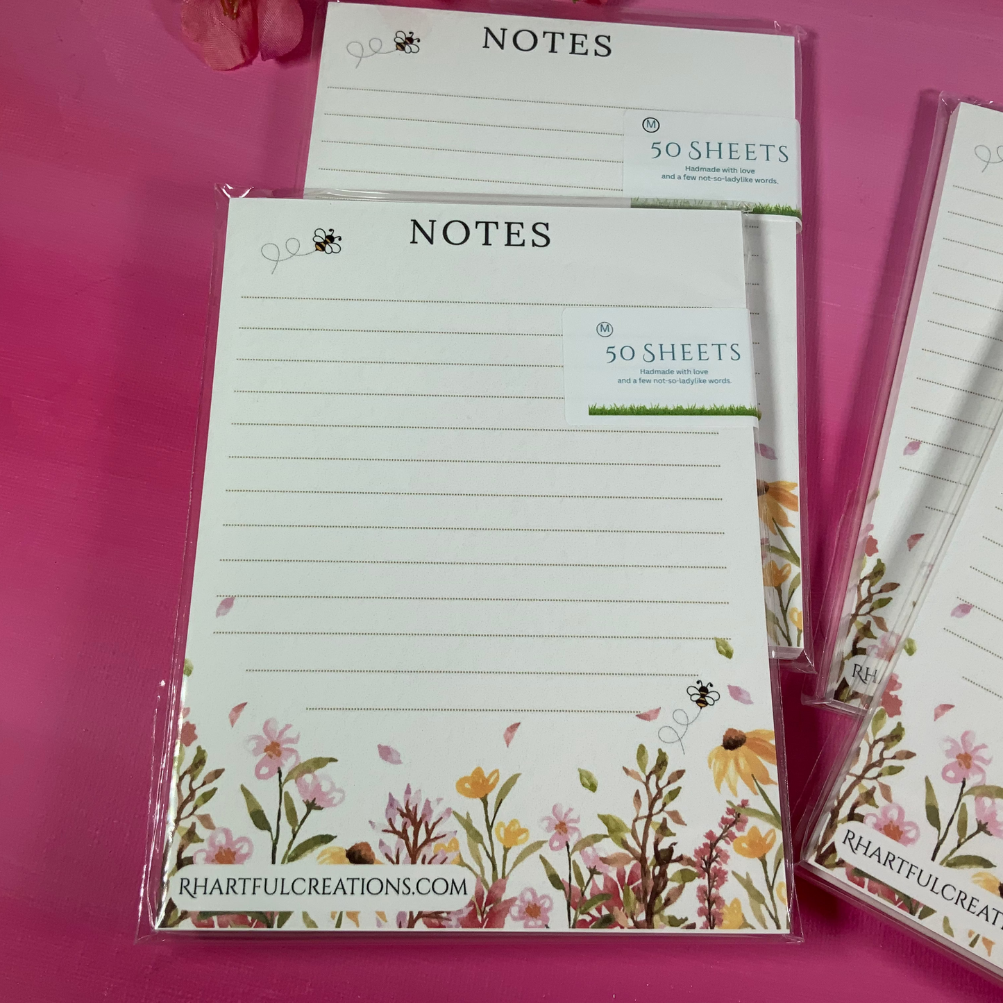 Notebooks with floral designs on a pink background