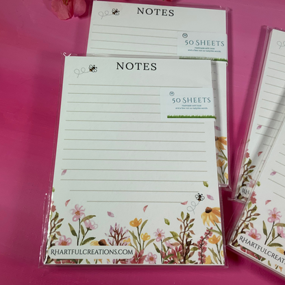 Notebooks with floral designs on a pink background