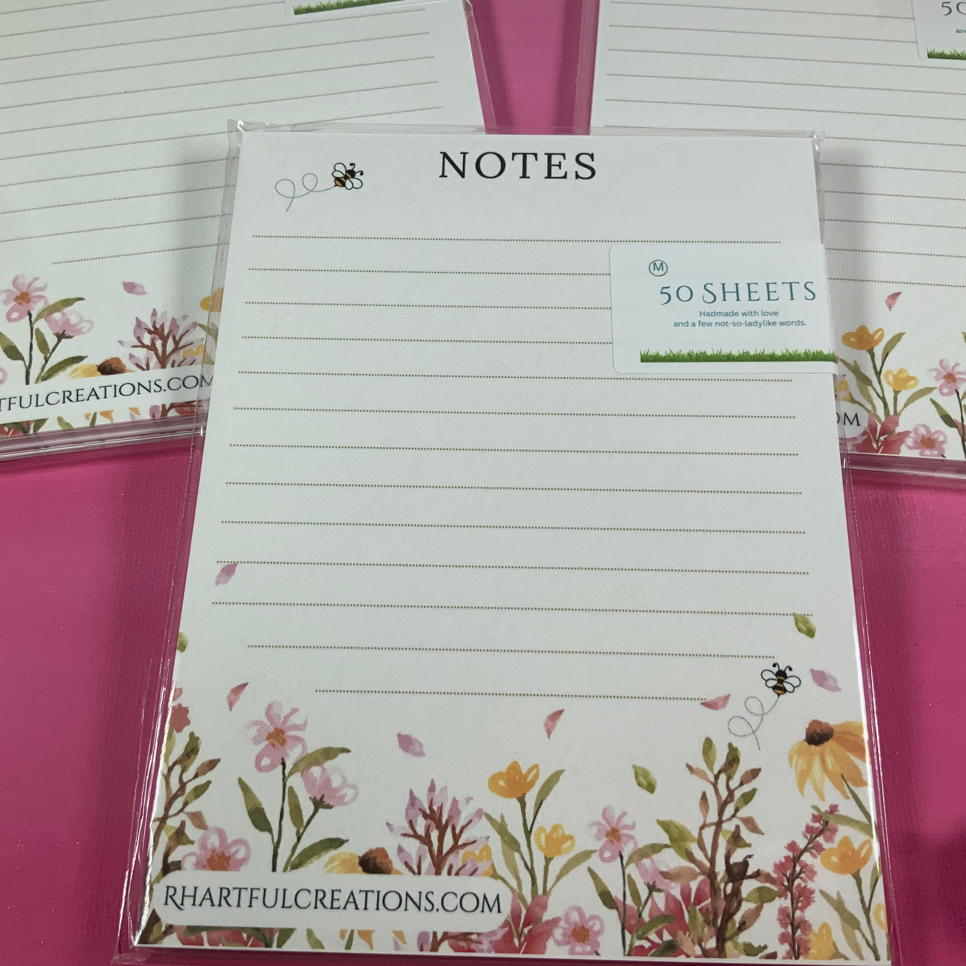 Floral notepads with lined paper on a pink background