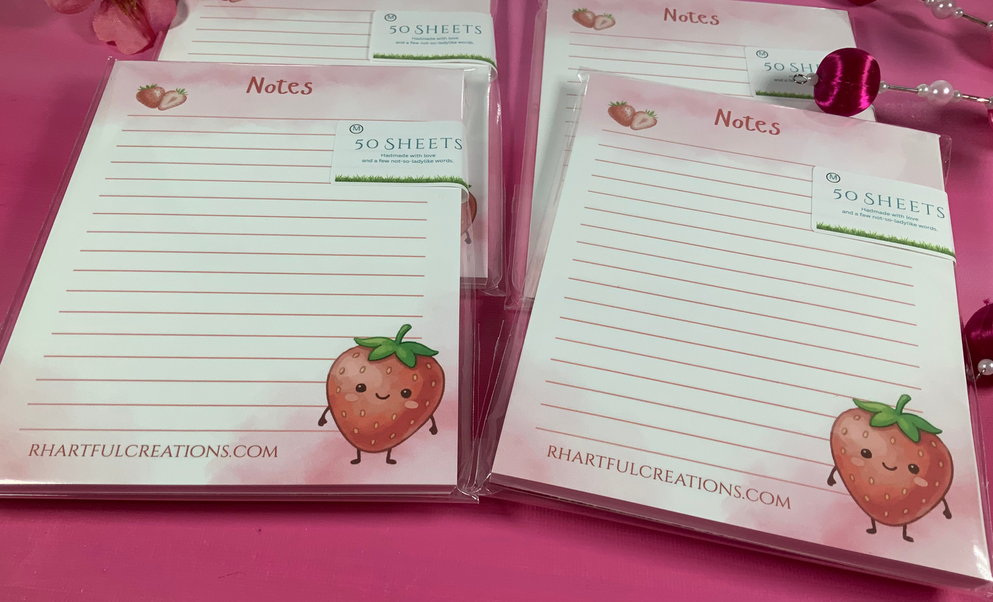 Note pads with strawberry design on a pink background