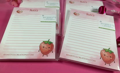 Note pads with strawberry design on a pink background