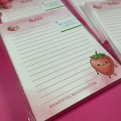Notepads with strawberry design and 'Notes' text on a pink surface