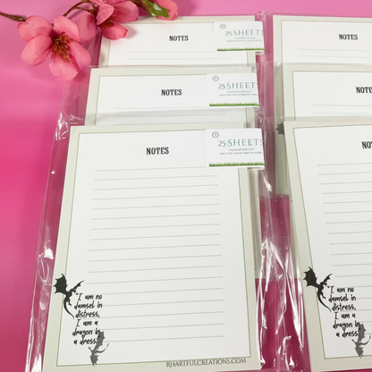 Set of note pads with silhouette designs on a pink background