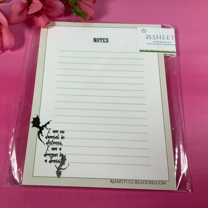 Notepad with lined pages and text on a pink background