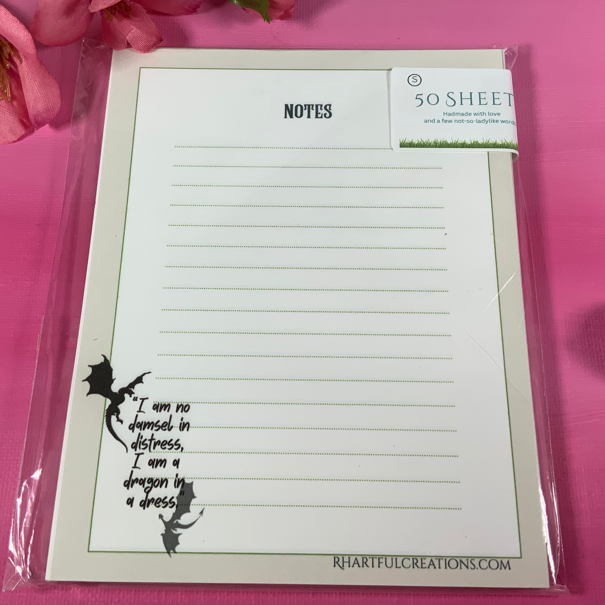 Notepad with text and illustration on a pink background with flowers and earrings.