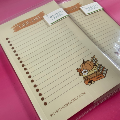Notebook with lined pages and a cartoon pumpkin design on a pink background