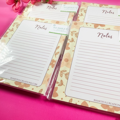 Notebook with lined pages and floral design on a pink surface