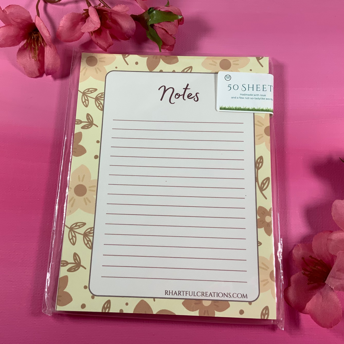 Notepad with floral design on a pink background