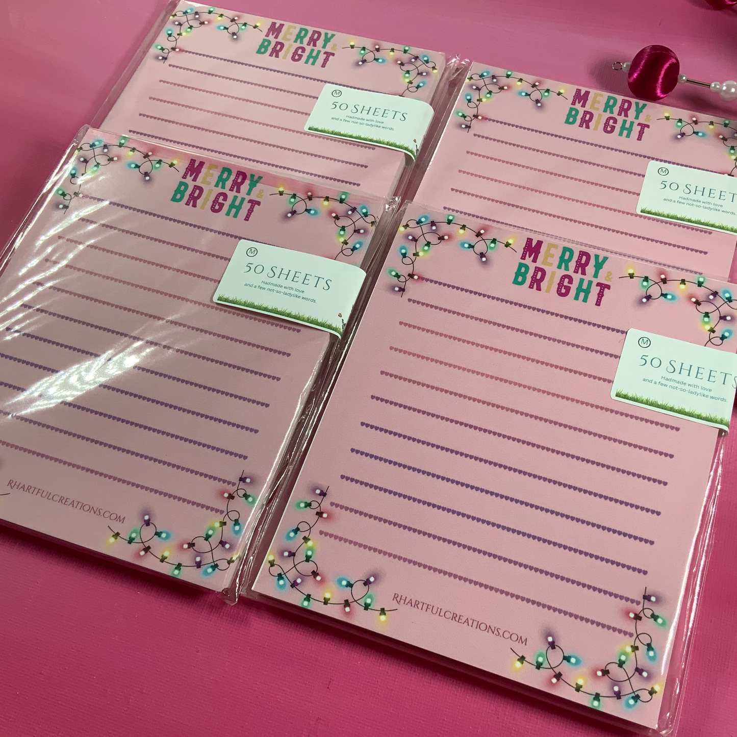 Set of pink notepads with 'Merry Bright' text on a pink background