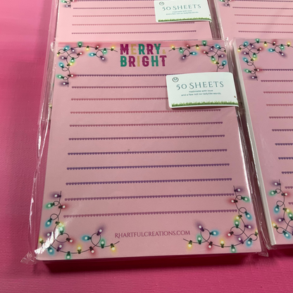 Pink notepads with Christmas lights design on a pink background